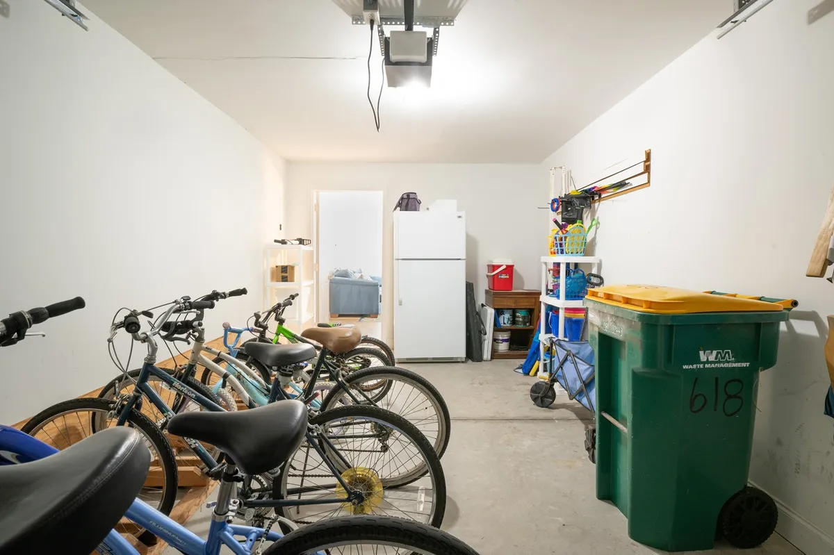A practical storage space with several bicycles, a refrigerator, and bins, highlighting the availability of complimentary bikes for guests. The organization of the area suggests readiness for outdoor exploration.